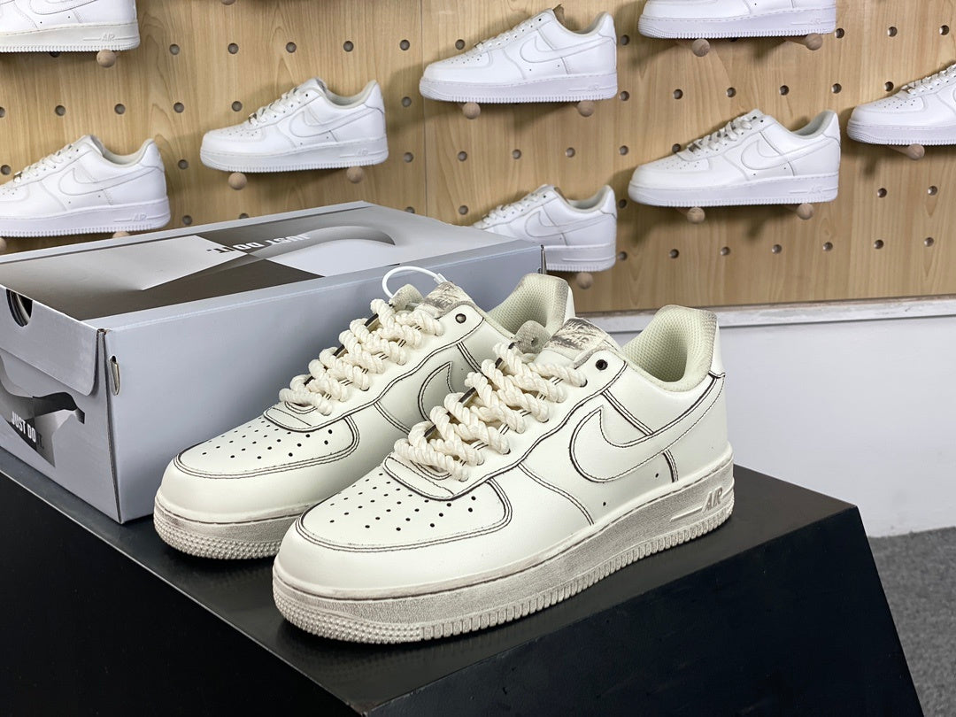 Cream low-top sneakers with rope laces and dark contrast stitching