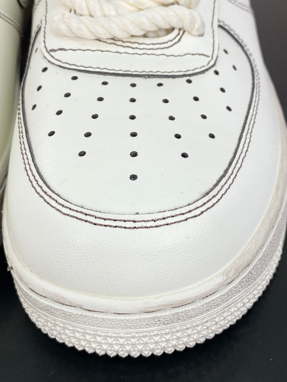 Cream low-top sneakers with rope laces and dark contrast stitching